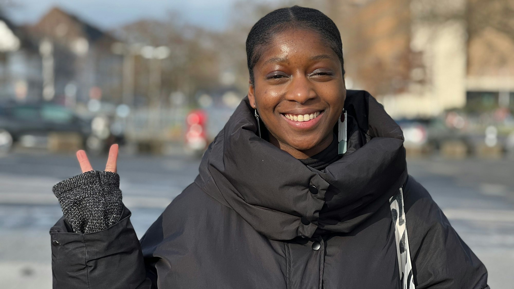Die 26-jährige Studentin Elisa Diamuangana schaut in die Kamera und lacht.