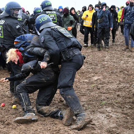 Zwei Polizisten ziehen einen Demonstranten während der Proteste gegen den Abriss von Lützerath weg.