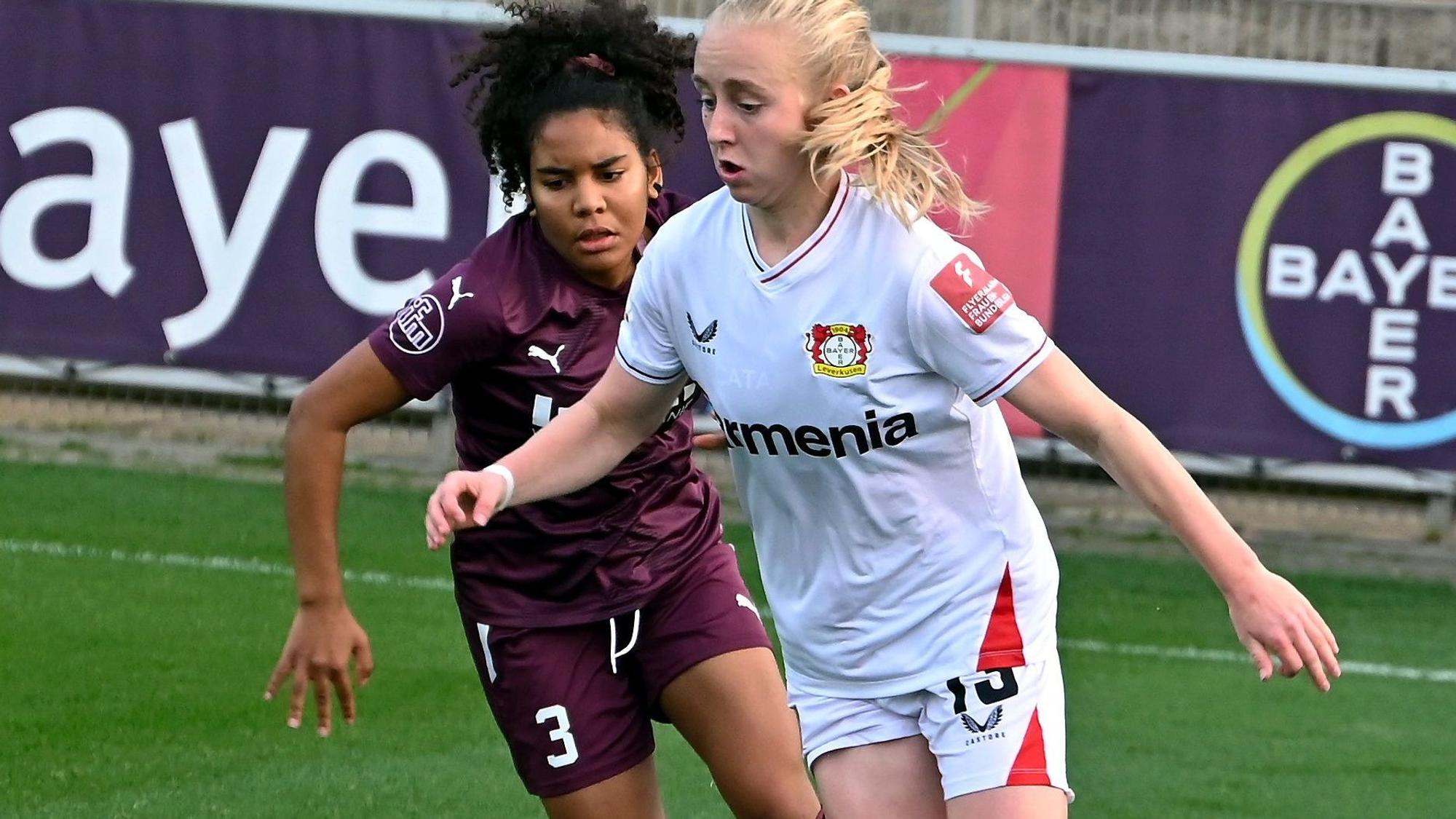 Zwei Fußballerinnen befinden sich im Zweikampf.