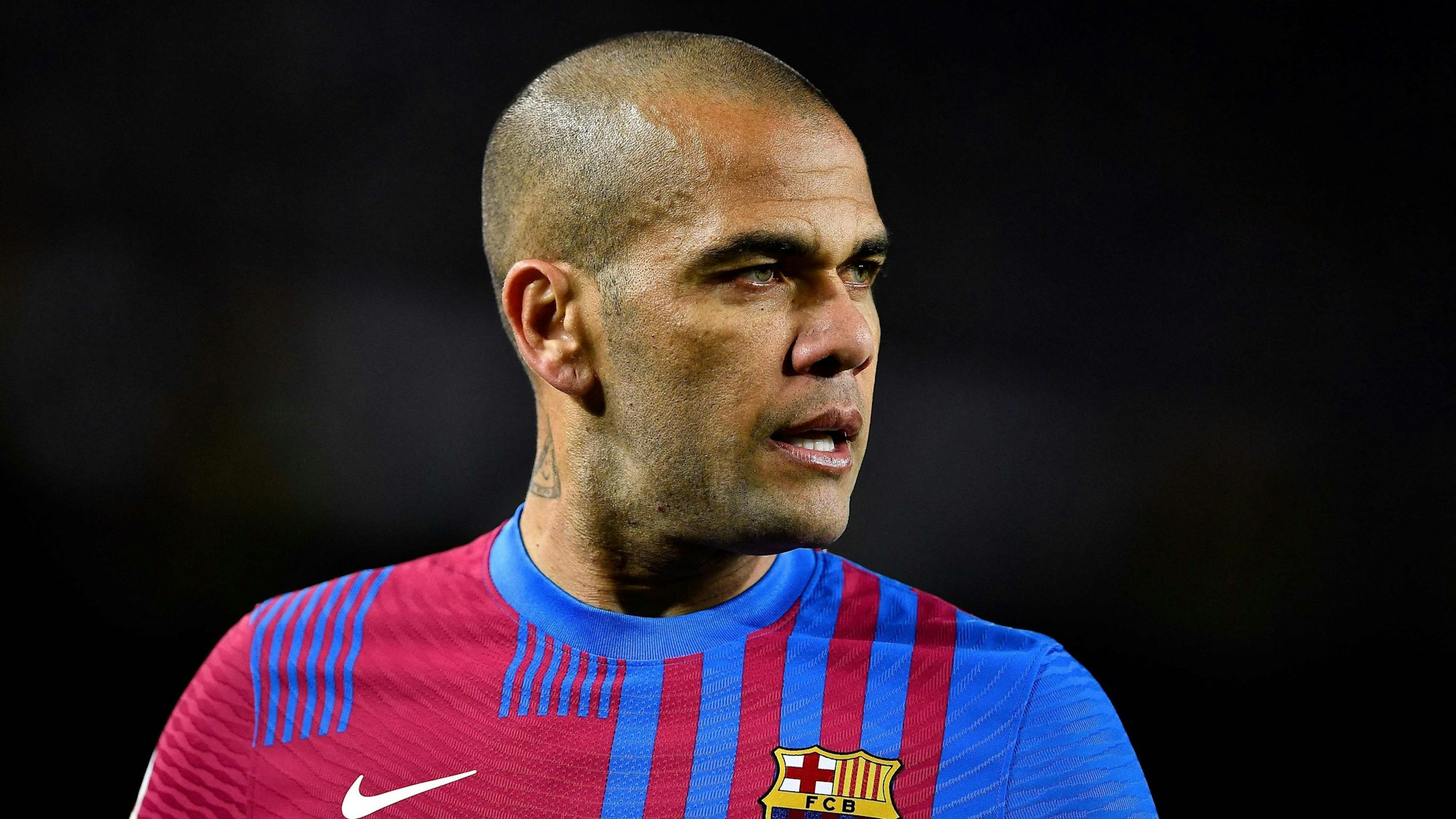 (FILES) In this file photo taken on February 27, 2022 Barcelona's Brazilian defender Dani Alves looks on during the Spanish league football match between FC Barcelona and Athletic Club Bilbao at the Camp Nou stadium in Barcelona. - Former Brazil defender Dani Alves was taken into custody on January 20, 2023 in Spain over allegations that he sexually assualted a woman at a Barcelona nightclub in December, police said. The 39-year-old player was summoned to a Barcelona police station where he was "taken into custody" and will now be questioned by a judge, said a spokesman for Catalonia's regional police force, the Mossos d'Esquadra. (Photo by Pau BARRENA / AFP)