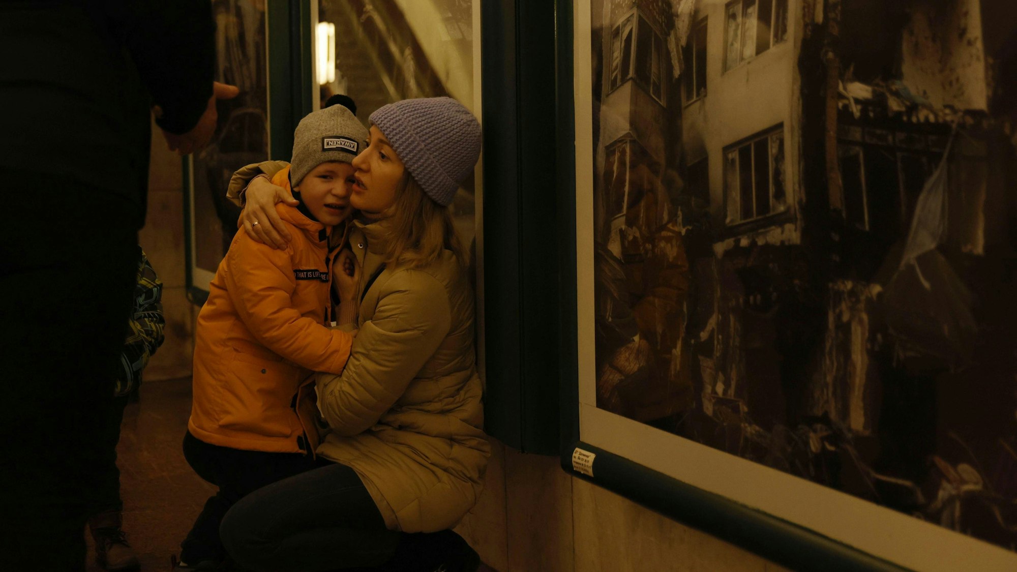 Kiew: Eine Mutter tröstet ihr Kind, während Menschen an Silvester Schutz in einer U-Bahn-Station suchen.