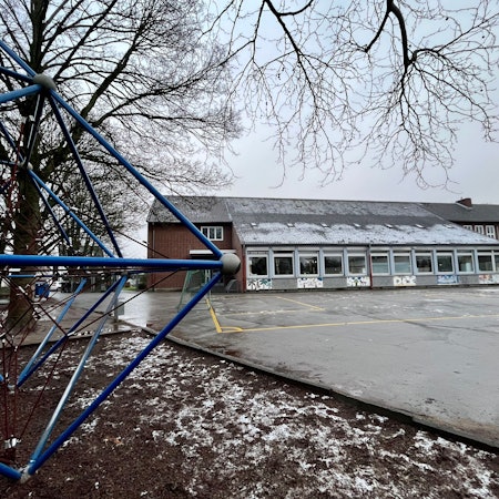 Blick über einen Schulhof auf ein Schulgebäude