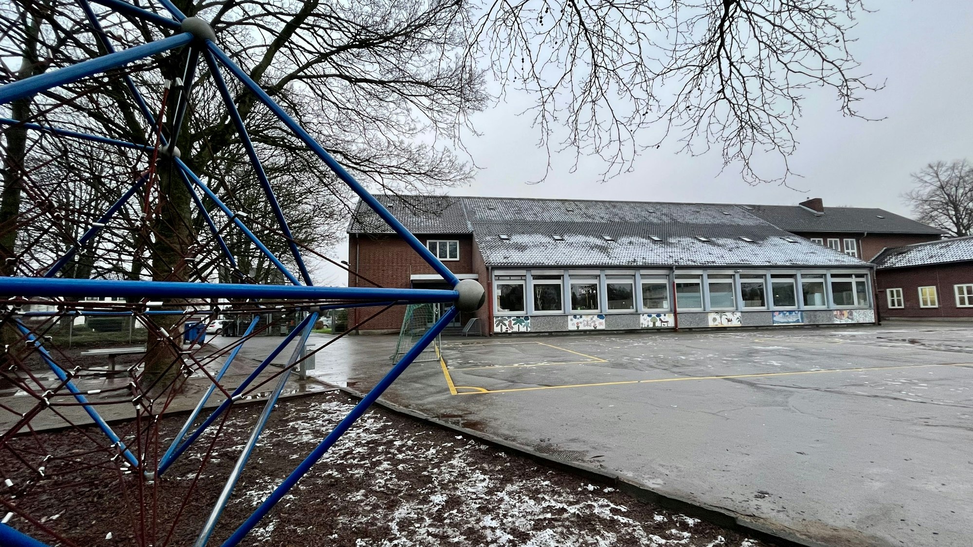 Blick über einen Schulhof auf ein Schulgebäude