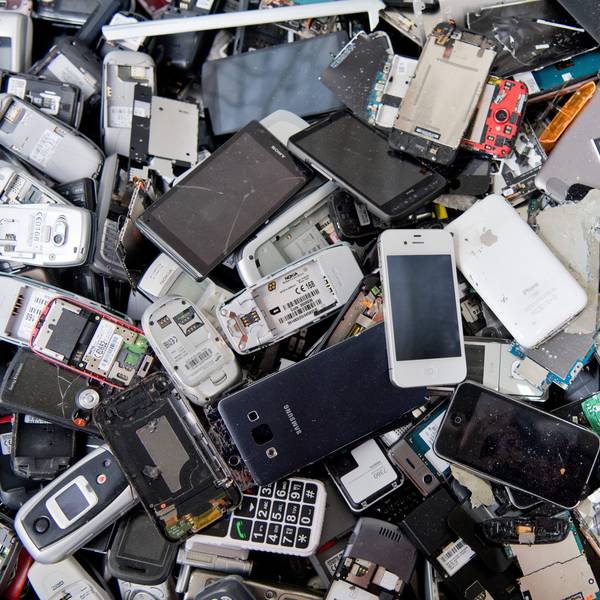 Alte Handys und Smartphones liegen in einem Container, ehe sie geschreddert werden.