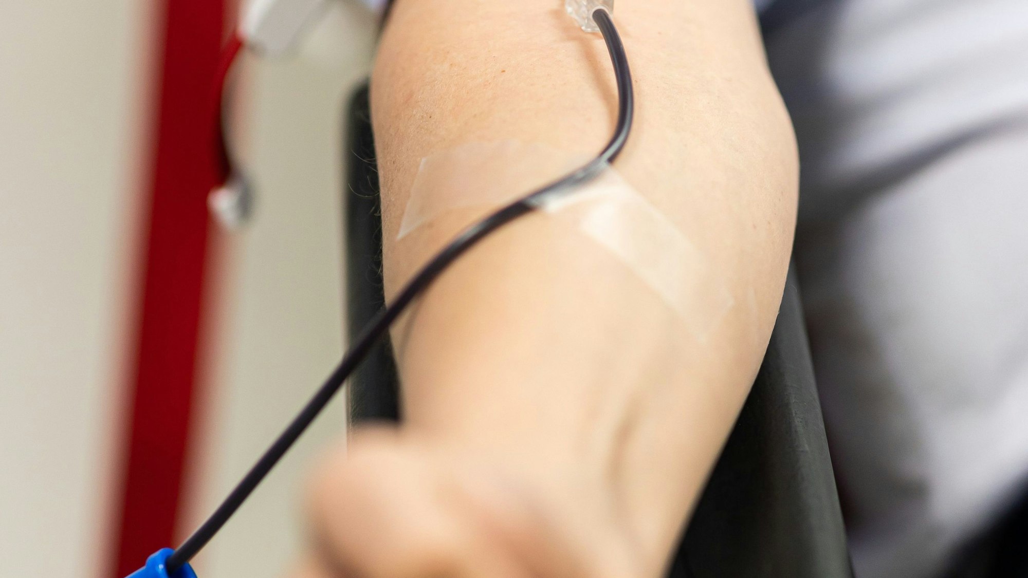 Ein Mann sitzt bei einem Blutspendedienst und spendet Vollblut.