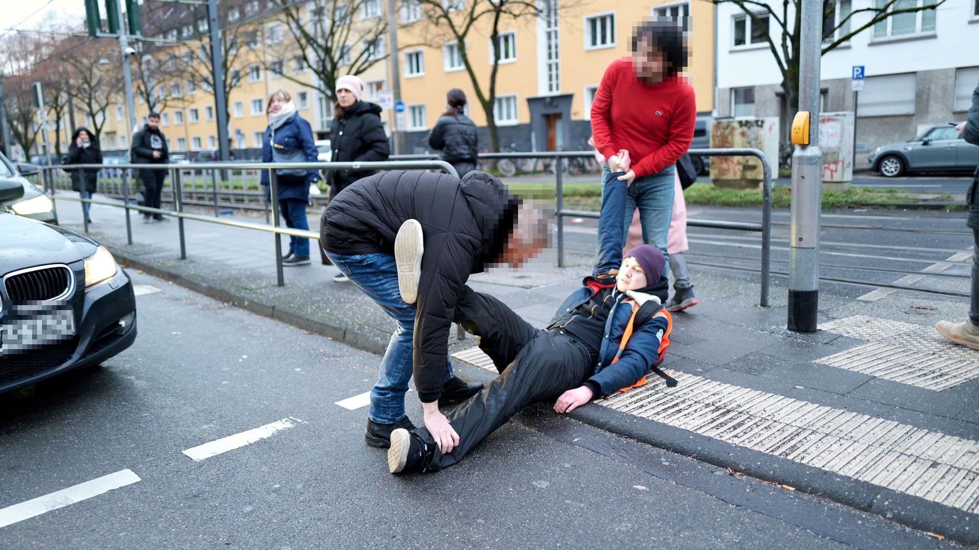 20. Januar 2023: Zwei Autofahrer zerren einen Aktivisten weg, der sich auf die Aachener Straße gesetzt hatte.