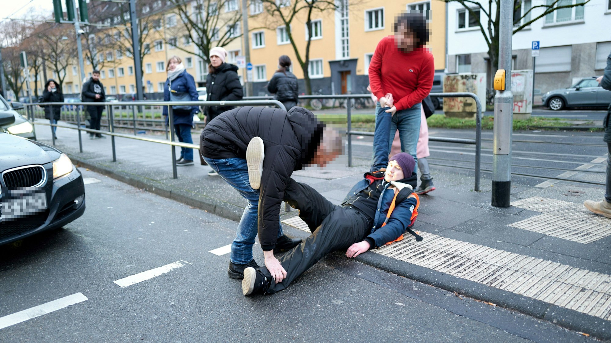20. Januar 2023: Zwei Autofahrer zerren einen Aktivisten weg, der sich auf die Aachener Straße gesetzt hatte.