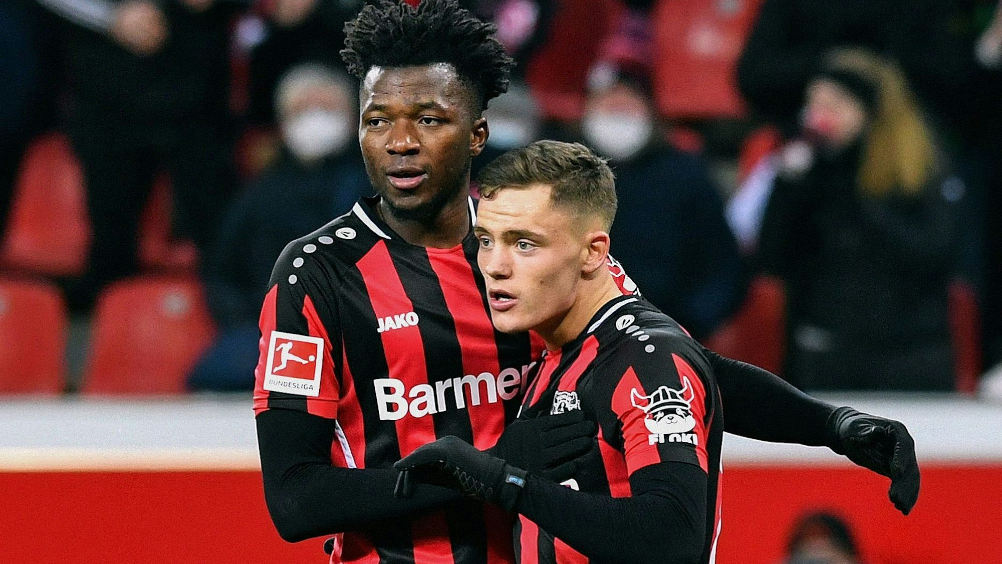 Leverkusen's German forward Florian Wirtz (R) celebrates scoring with his teammate Leverkusen's Burkinabe defender Edmond Tapsoba during the German first division Bundesliga football match Bayer 04 Leverkusen v VfB Stuttgart in Leverkusen on February 12, 2022. (Photo by UWE KRAFT / AFP) / DFL REGULATIONS PROHIBIT ANY USE OF PHOTOGRAPHS AS IMAGE SEQUENCES AND/OR QUASI-VIDEO