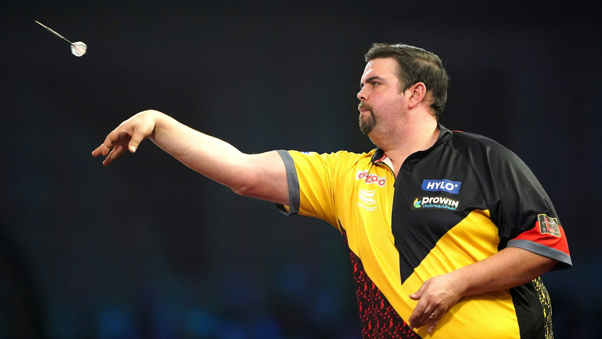 Ein Mann wirft einen Darts-Pfeil.