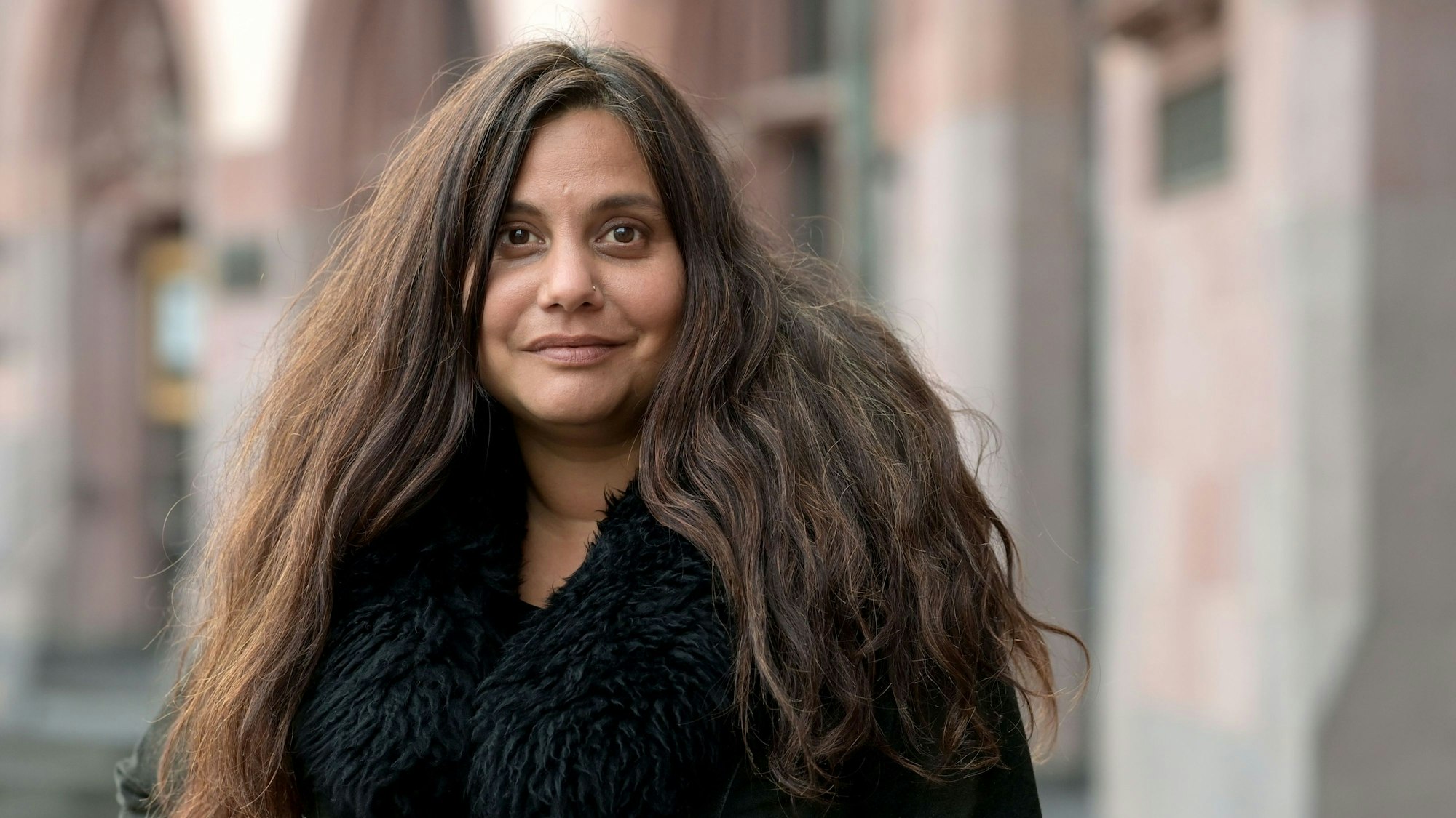 Die Autorin Mithu Sanyal schaut in die Kamera.