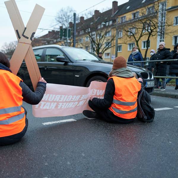 Aktivisten der „Letzten Generation“ kleben sich auf einer Fahrbahn ist Köln fest.