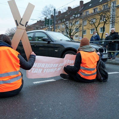 Aktivisten der „Letzten Generation“ kleben sich auf einer Fahrbahn ist Köln fest.