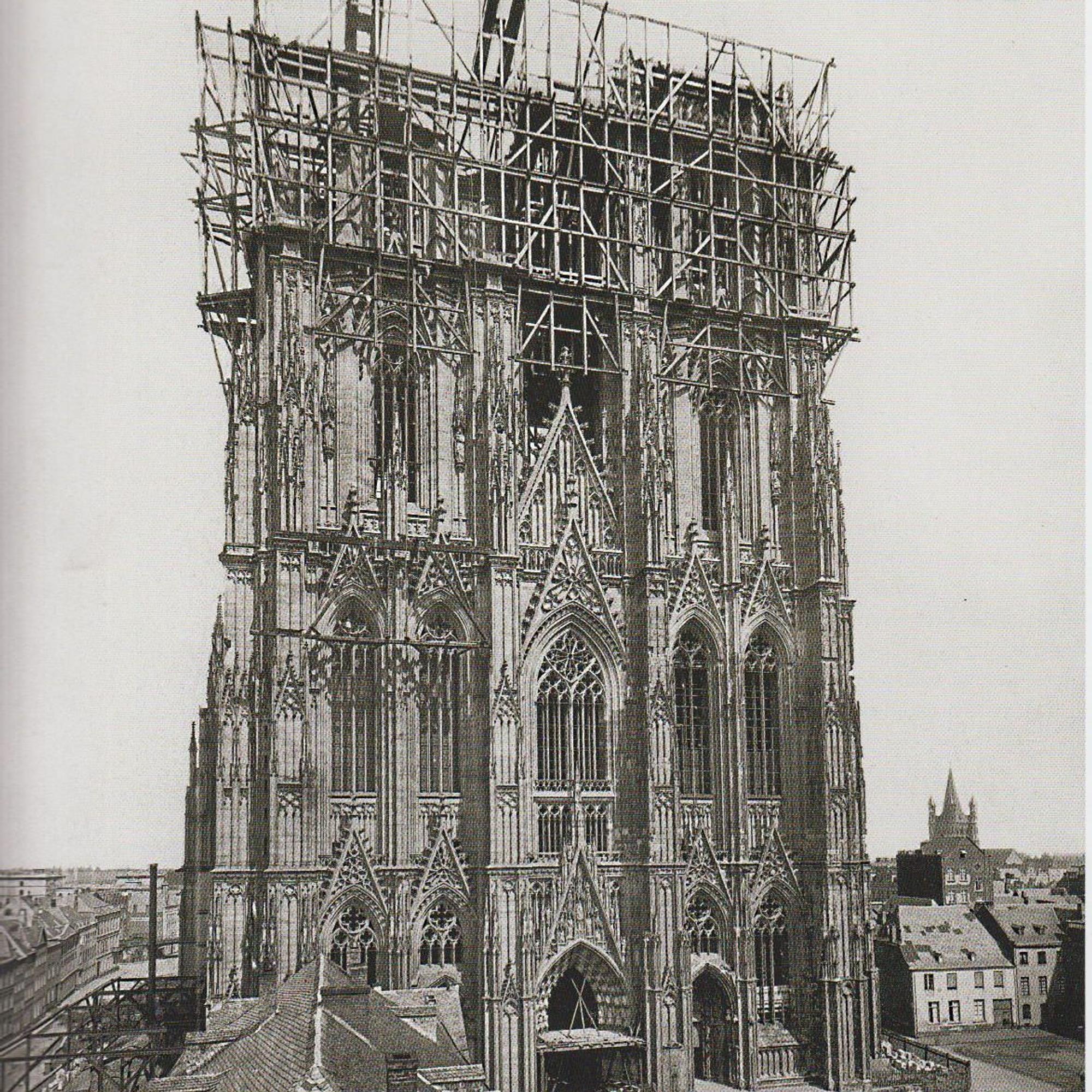 Das historische Foto vom Weiterbau des Kölner Doms im 19. Jahrhundert zeigt ein Gerüst um die noch unvollendeten Türme der Kathedrale.