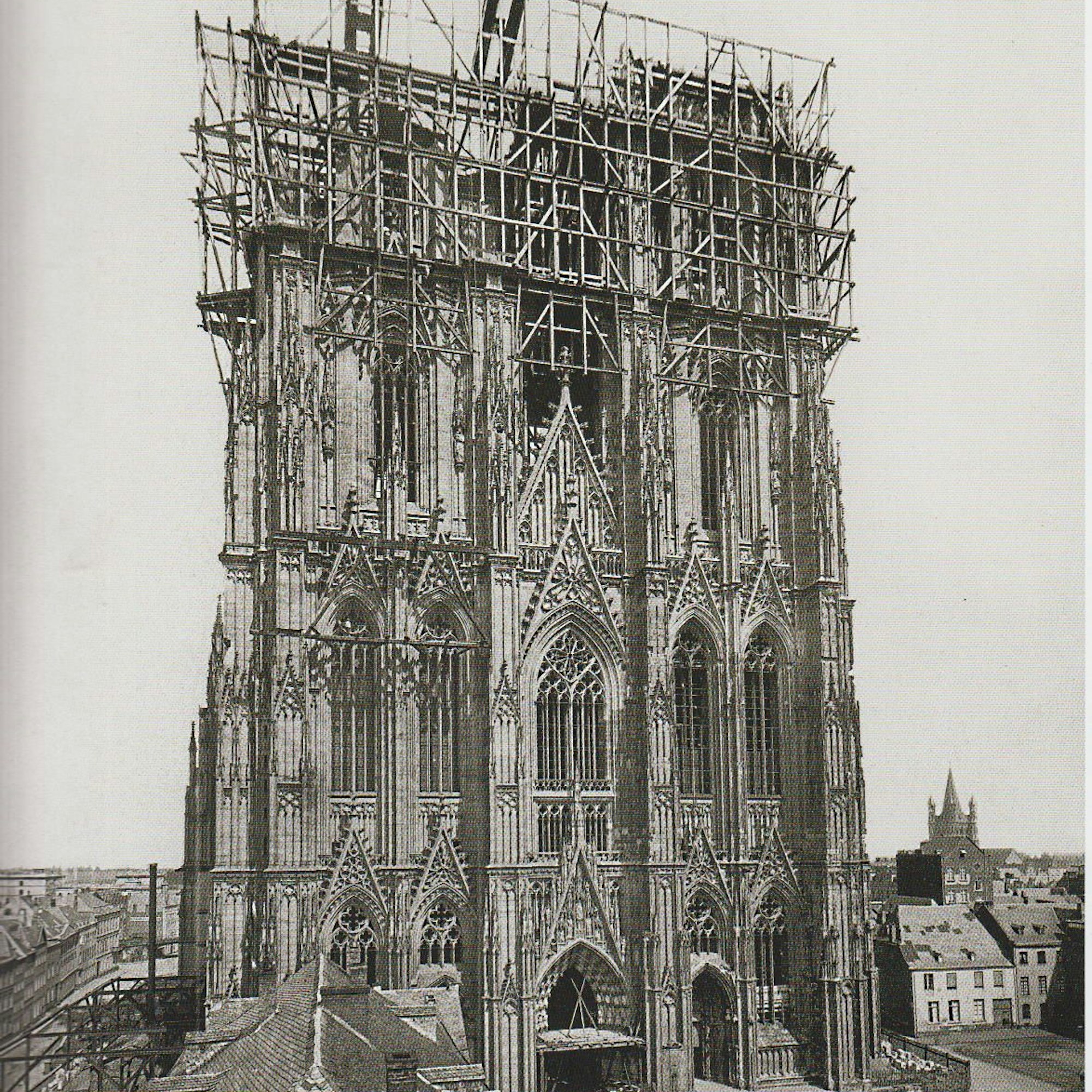 Das historische Foto vom Weiterbau des Kölner Doms im 19. Jahrhundert zeigt ein Gerüst um die noch unvollendeten Türme der Kathedrale.