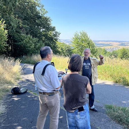 Ein Mann wird gefilmt, im Hintergrund ist Eifeler Landschaft zu sehen.