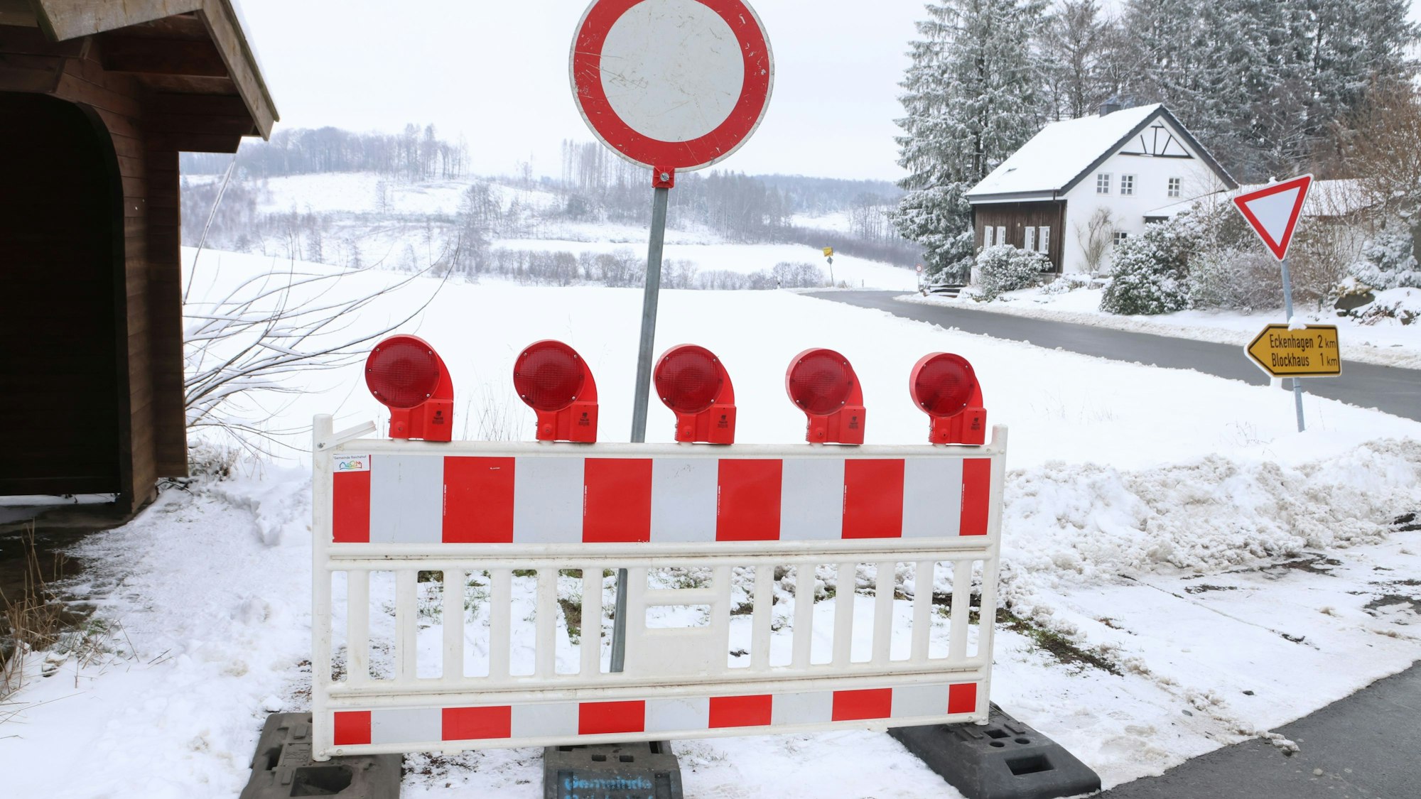Im Bild ist eine Absperrbarke neben einer Straße zu sehen.
