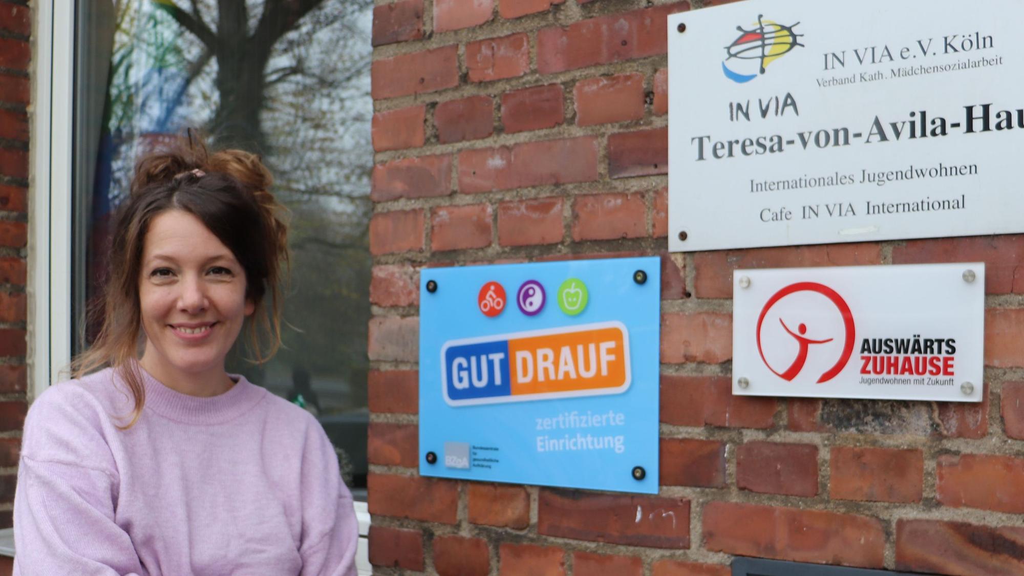 Sozialpädagogin Sandy Müller steht vor dem „In via“-Mädchenwohnheim, an dessen Wand die Zertifikate hängen.