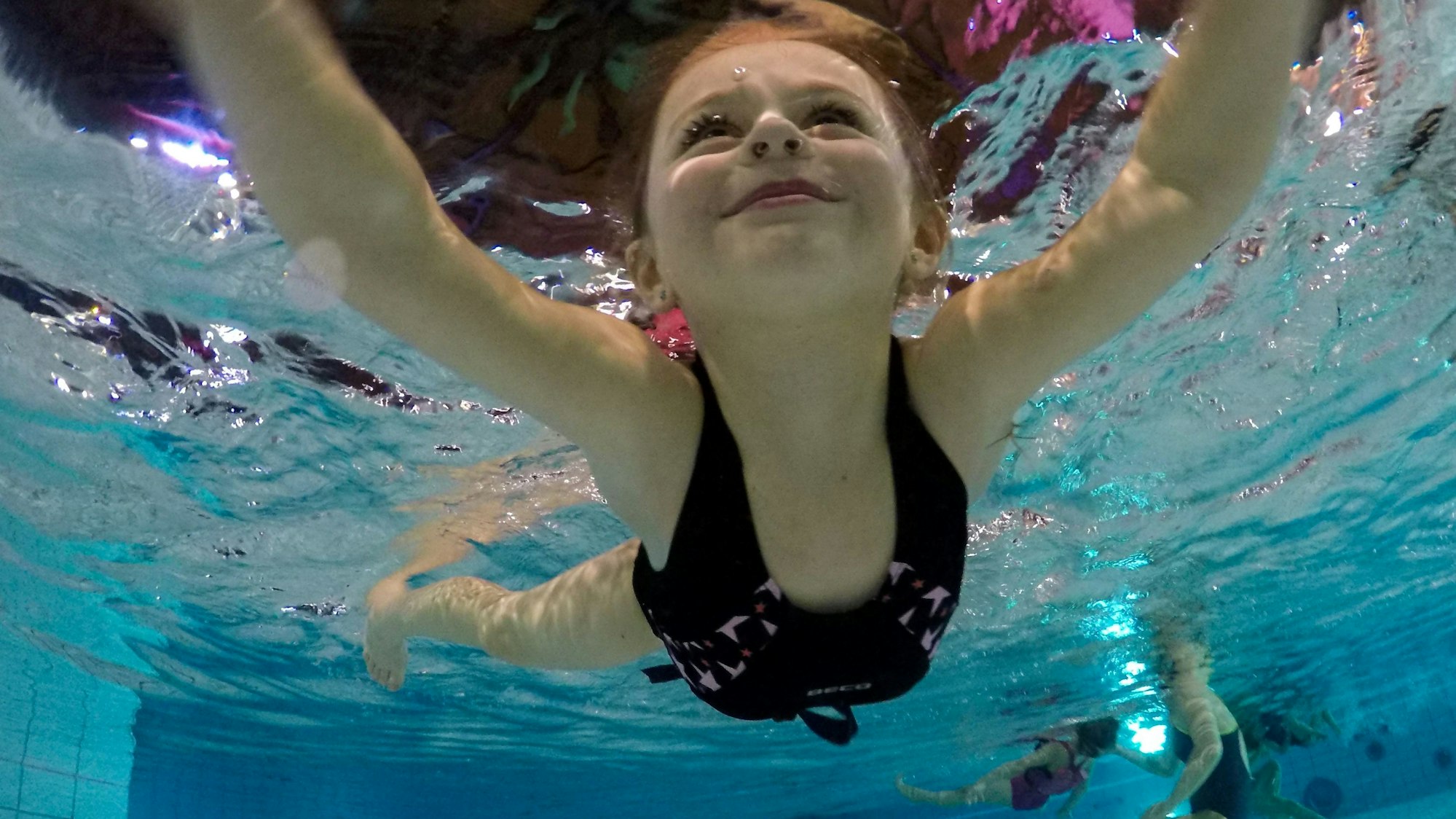 Ein Kind schwimmt in einem Schwimmbecken.