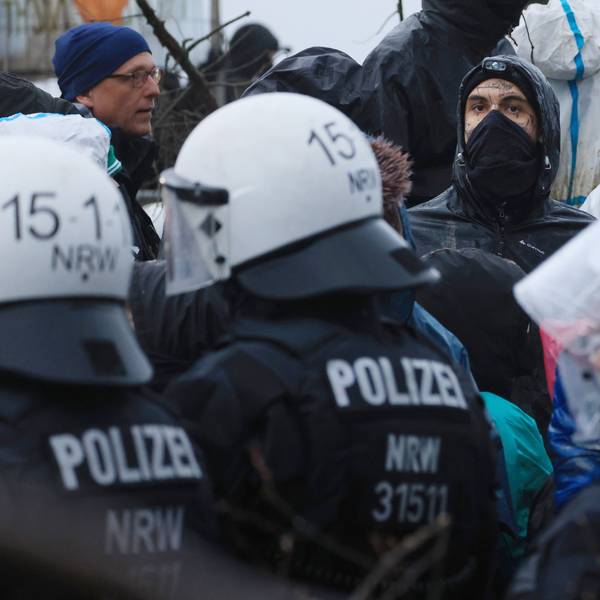 Aktivisten und Polizisten stehen sich am Rande des besetzten Braunkohleorts Lützerath direkt gegenüber.