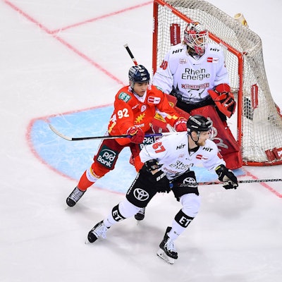 Es sind die Eishockeyspieler zu sehen, wie sie vor dem Tor stehen.