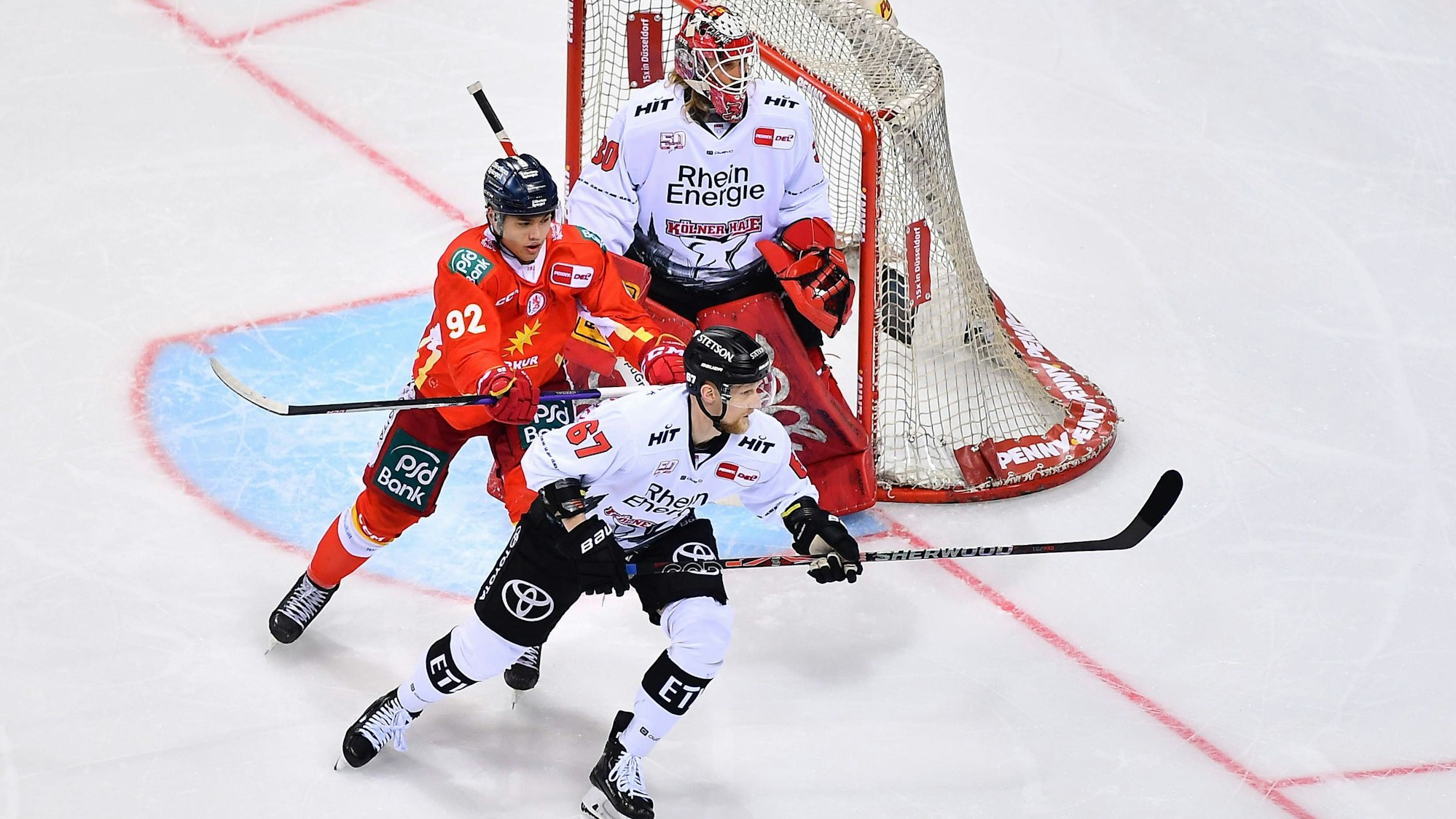 Es sind die Eishockeyspieler zu sehen, wie sie vor dem Tor stehen.