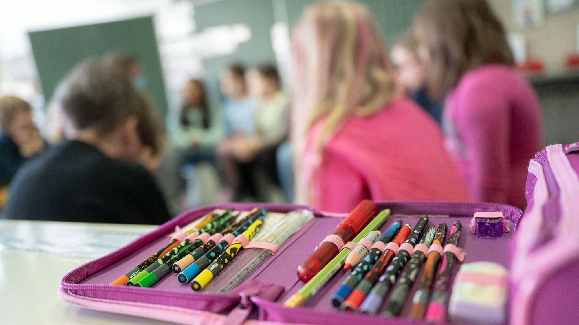 Ein Mäppchen liegt während des Unterrichts einer zweiten Klasse auf einem Tisch.