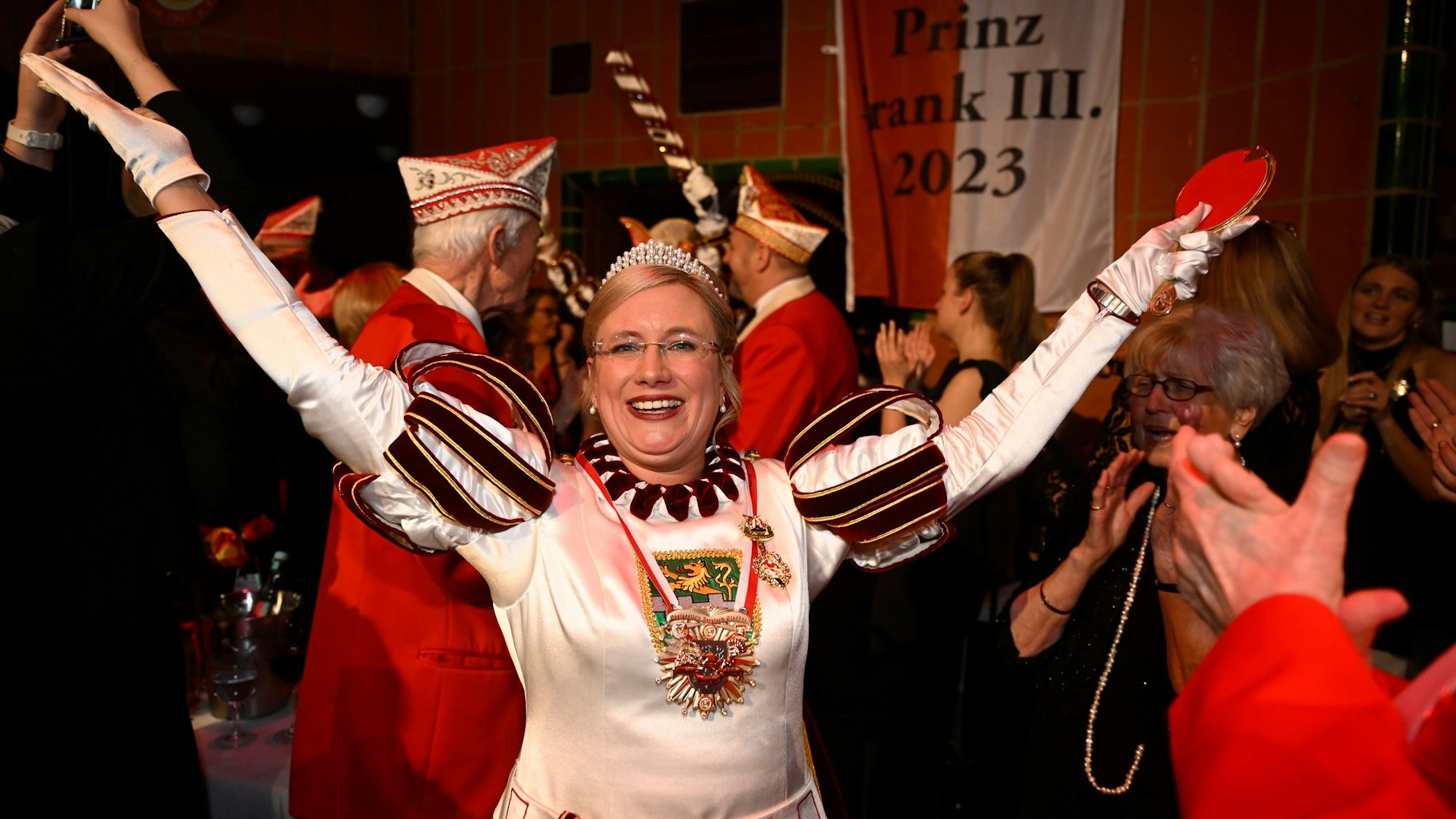 Jungfrau Melanie jubelt inmitten von Proklamationsgästen.