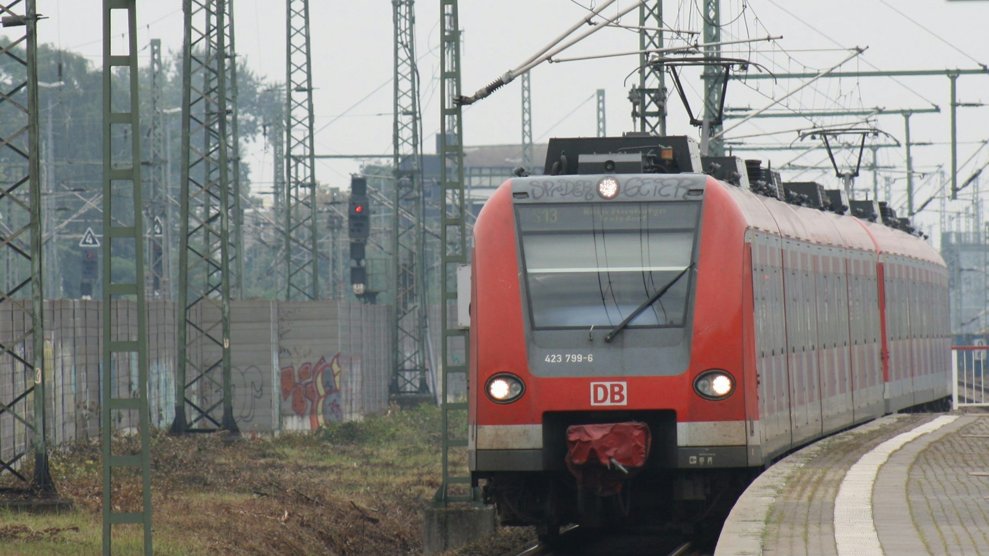 Eine roter Zug der S-Bahn-Linie 13 steht an einem Bahnsteig.