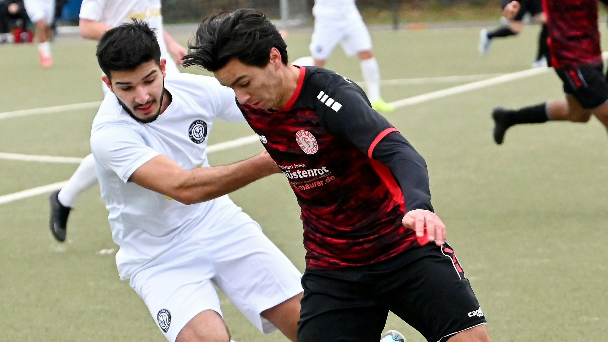 Zwei Fußballspieler bestreiten einen Zweikampf.