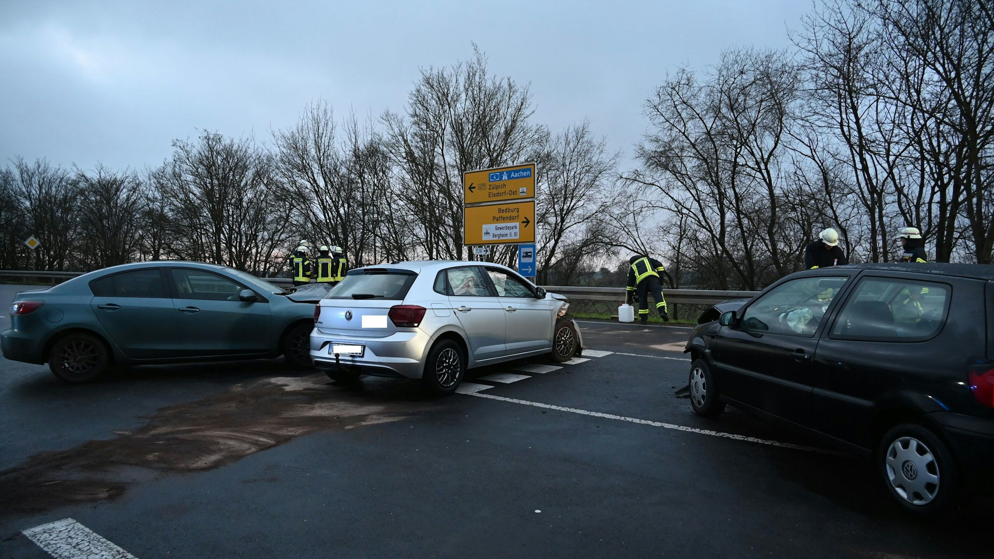 Drei Autos stehen auf einer Kreuzung und haben zerbeulte Fronten.