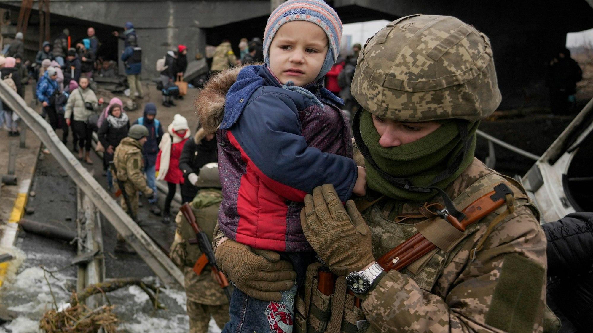 März 2022 in Kiew: Ein ukrainischer Soldat hält ein Baby, während er Menschen dabei hilft, aus der Stadt Irpin in der Ukraine zu fliehen.