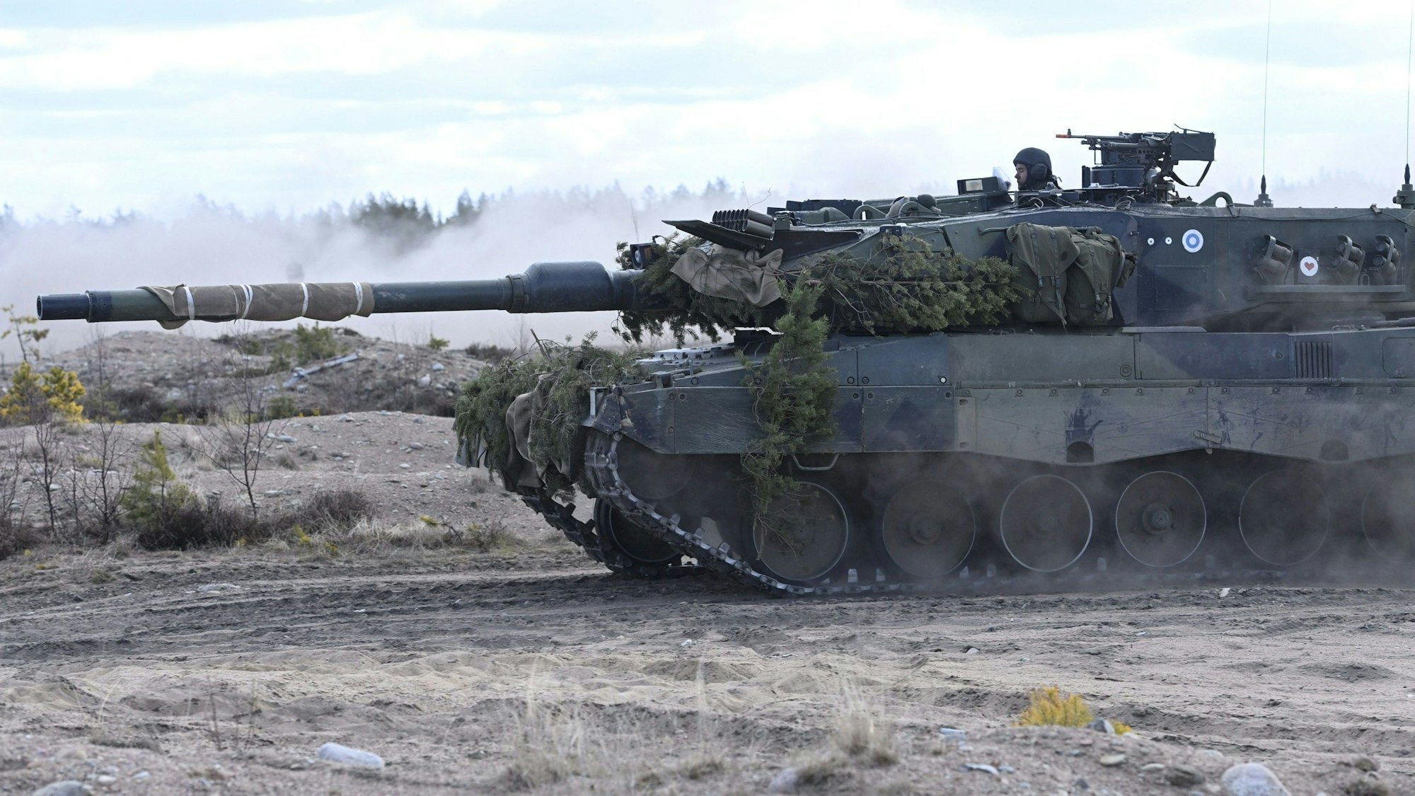 Ein Kampfpanzer von Typ Leopard der Panzerbrigade fährt auf einem Gelände.
