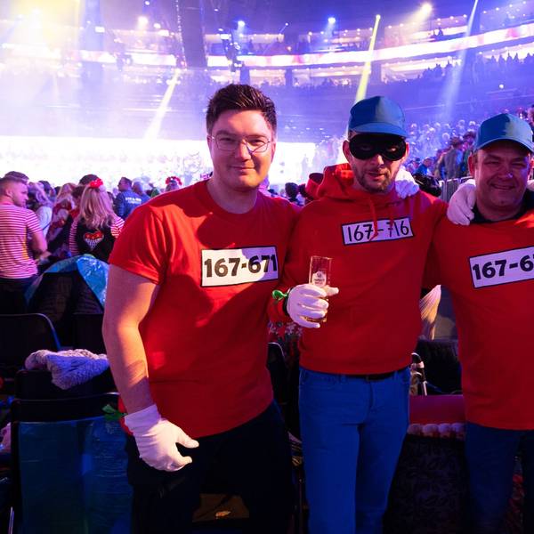 Vier als Panzerknacker verkleidete Männer stehen Arm in Arm in der Lanxess-Arena.