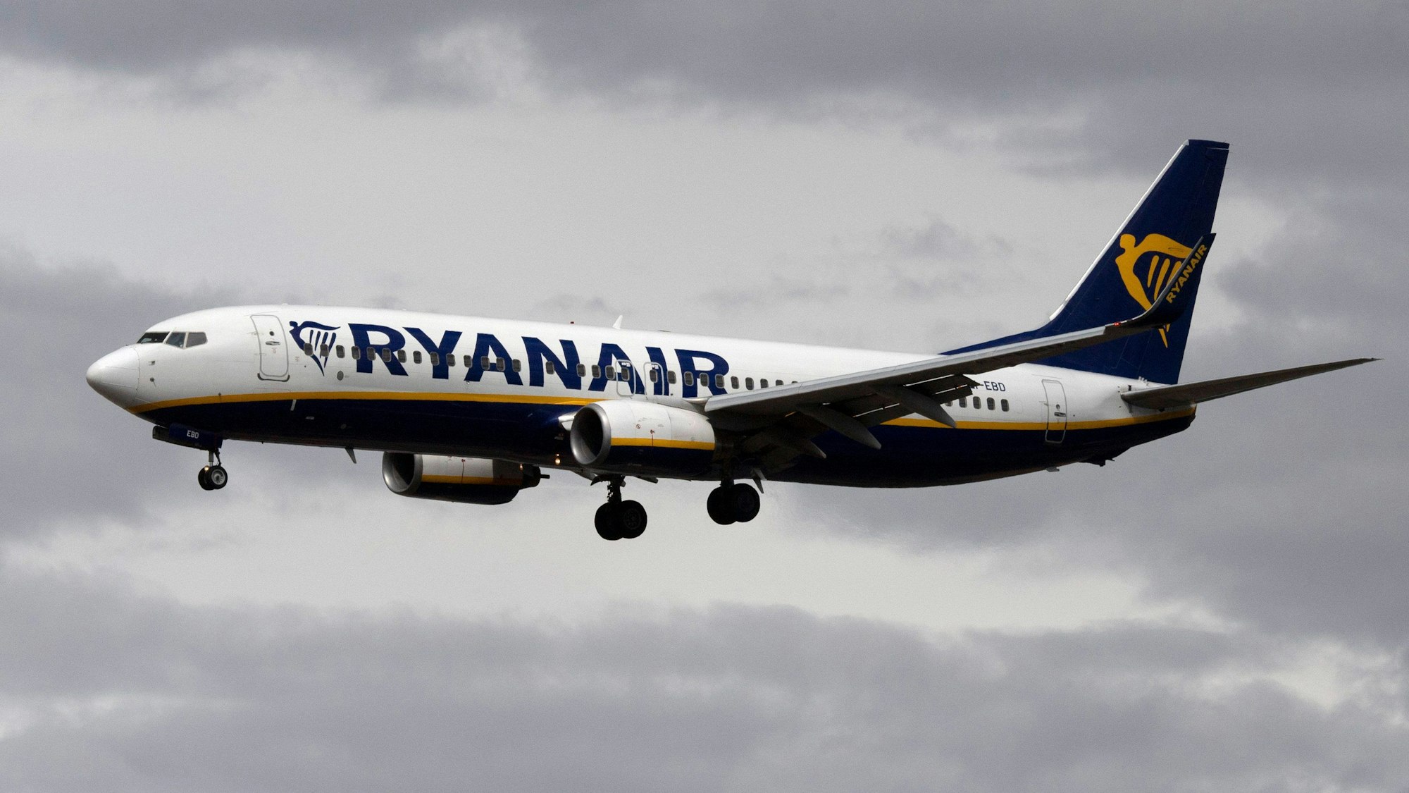 Eine Passagiermaschine von Ryanair setzt vor dunklen Wolken zum Landeanflug an.