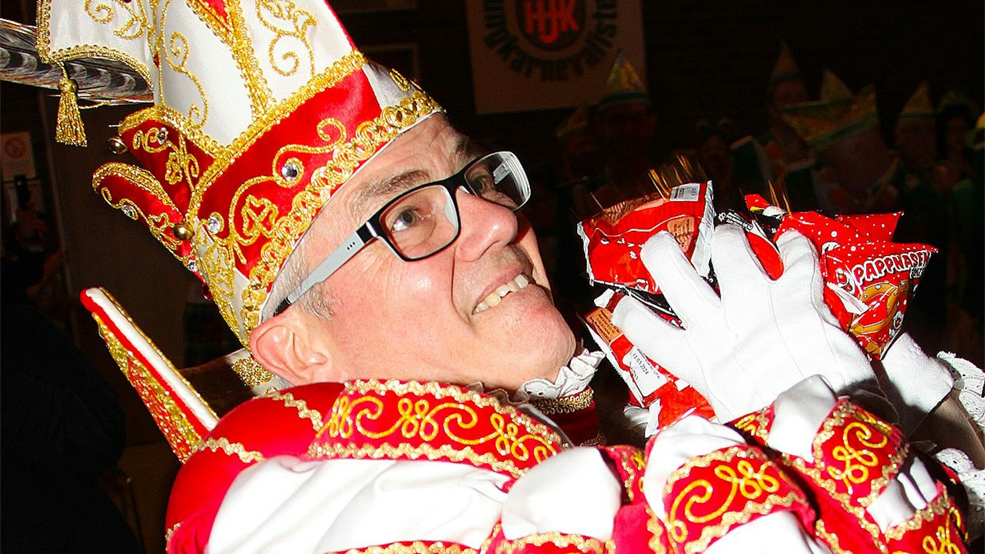 Zülpichs Prinz Rolf II. schmeißt Kamelle beim Einmarsch in den Saal.