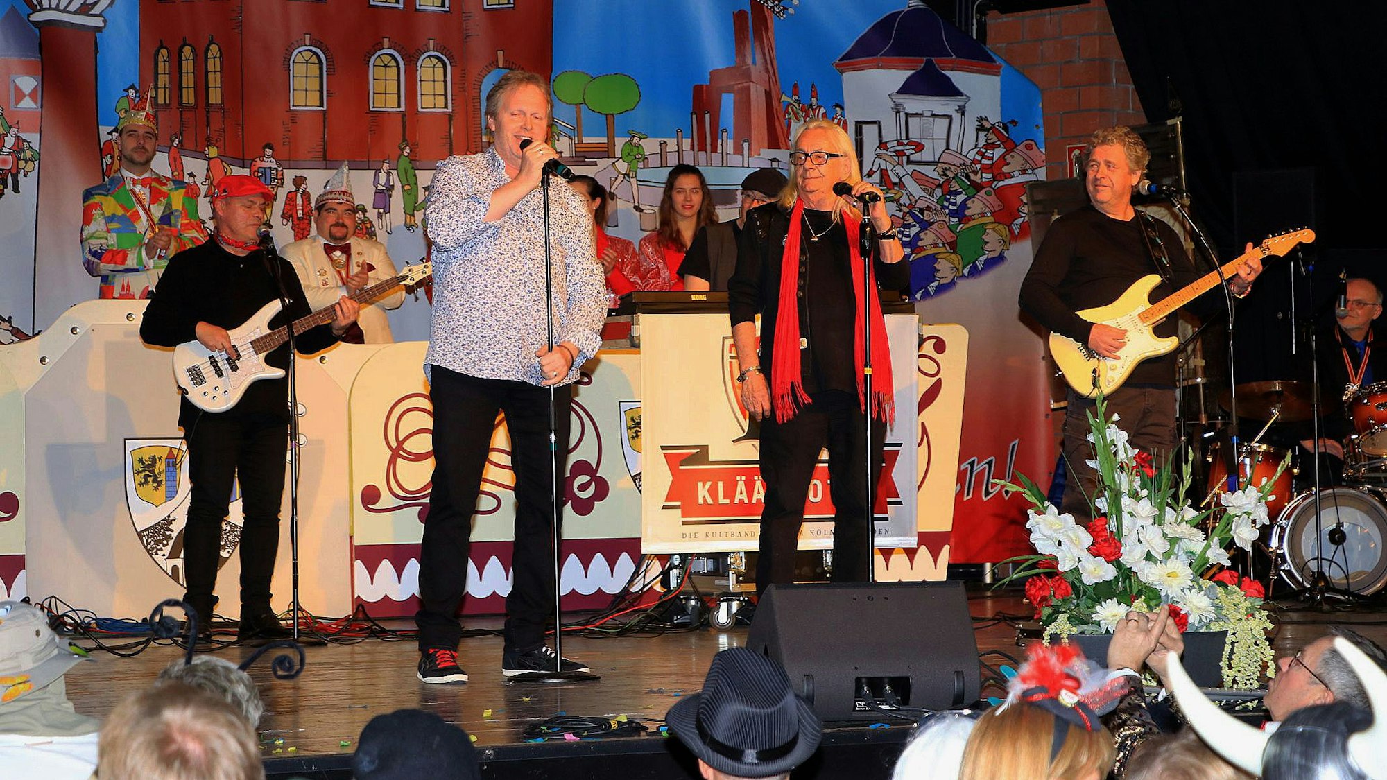 Die Kläävbotze sorgten schnell für eine gelungene Stimmung im Köster-Saal. Die Band steht auf der Bühne des festlich geschmückten Saales.