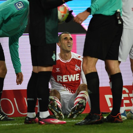Der Kölner Mittelfeldspieler Ellyes Skhiri sitzt am Boden, nachdem er sich am Sprunggelenk verletzt hat.