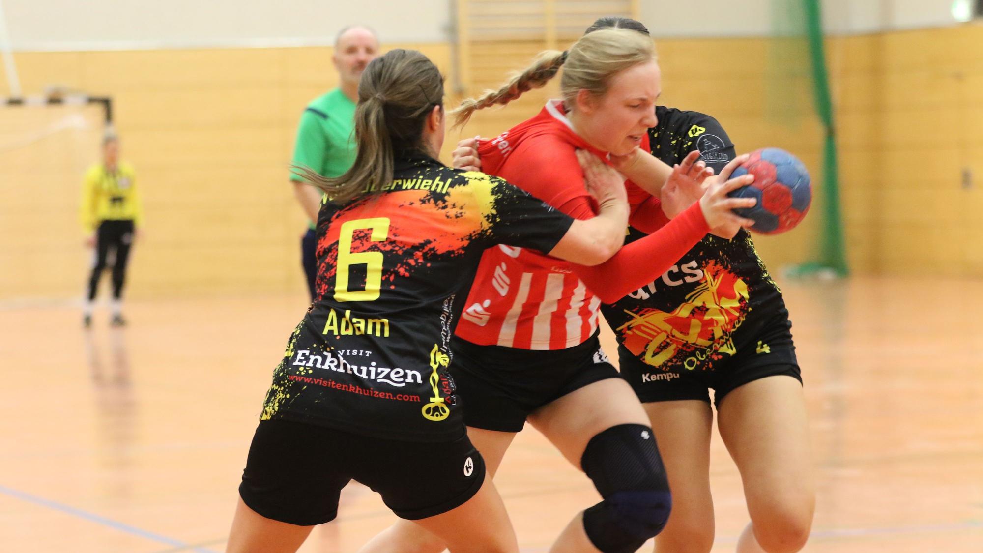 Euskirchens Spielern Lea Schmitz im Dreikampf mit zwei Gegnerinnen, von denen eine die Hand an Schmitz' Hals hat.