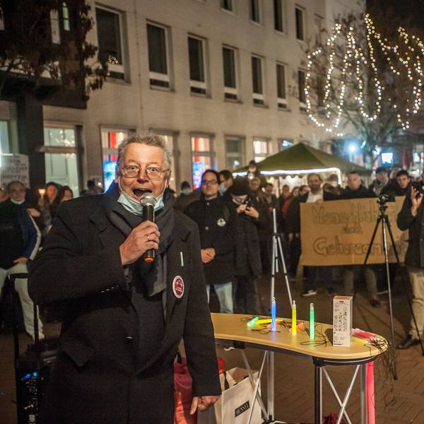Der Rechtsextremist und Rechtsanwalt Markus Beisicht (links)spricht in ein Mikrofon und schaut in die Kamera. Hier wird er im Januar 2022 vom Neonazi Alexander Kurth (beige Hose) bei einer Demonstration gefilmt.