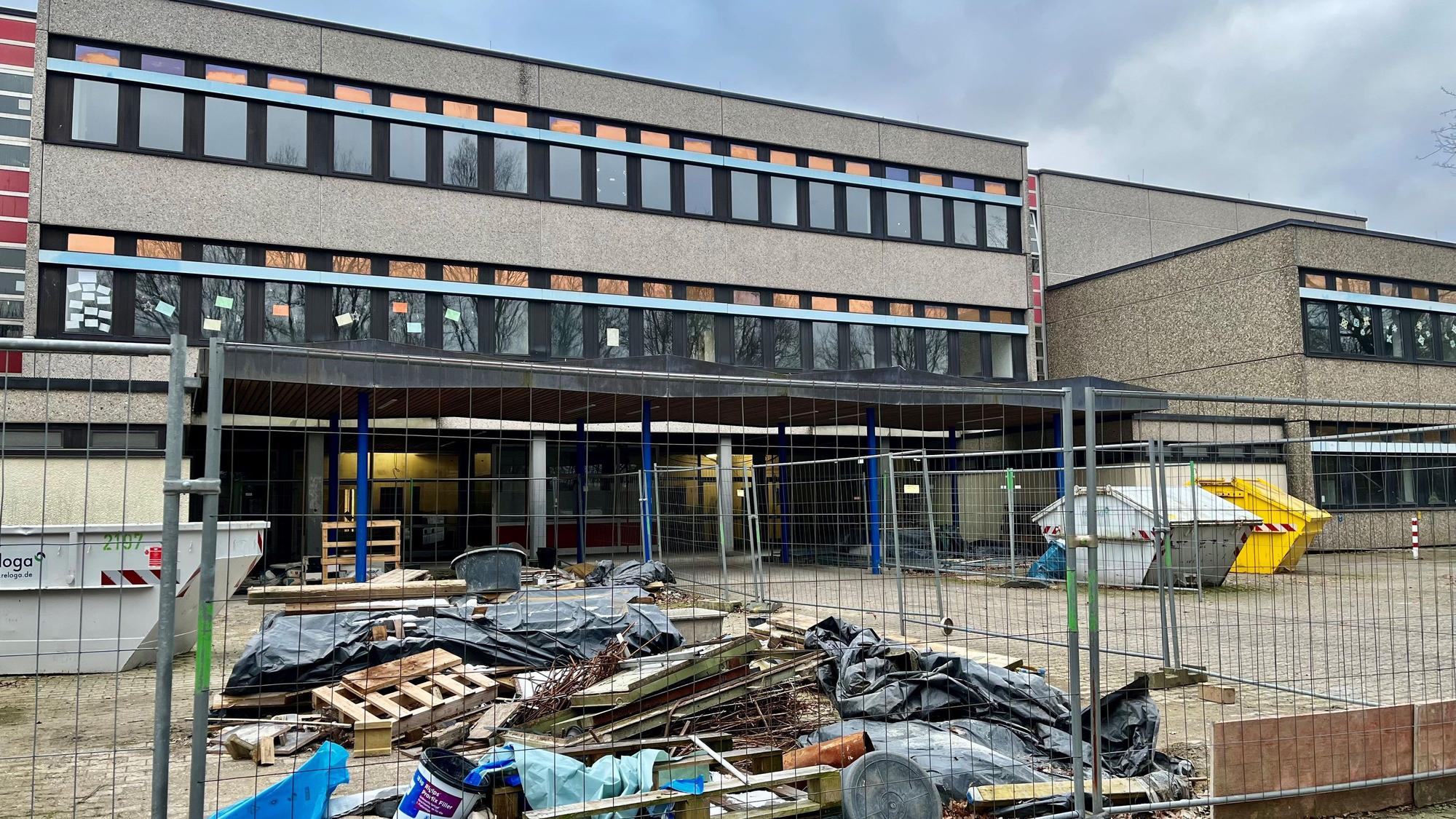 Ein Bauzaun und Bauschutt vor dem Hintereingang des Gymnasiums.