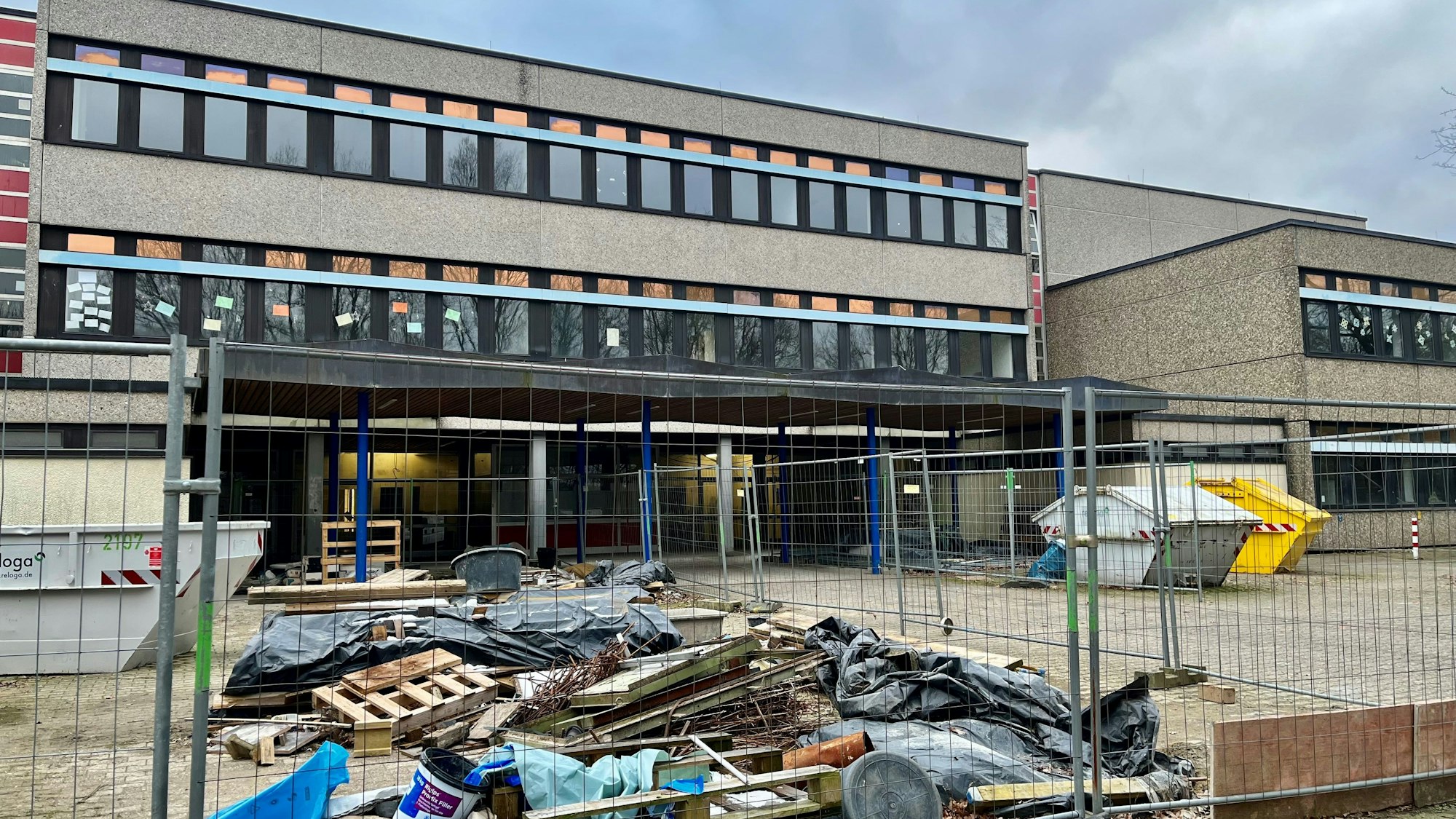 Ein Bauzaun und Bauschutt vor dem Hintereingang des Gymnasiums.