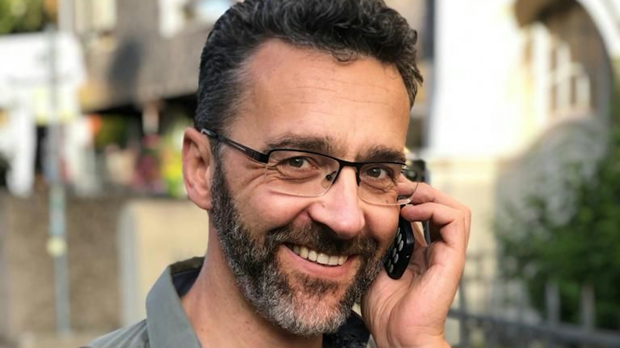 Kinderarzt Axel Gerschlauer aus Bonn hält sich ein Mobiltelefon ans Ohr.