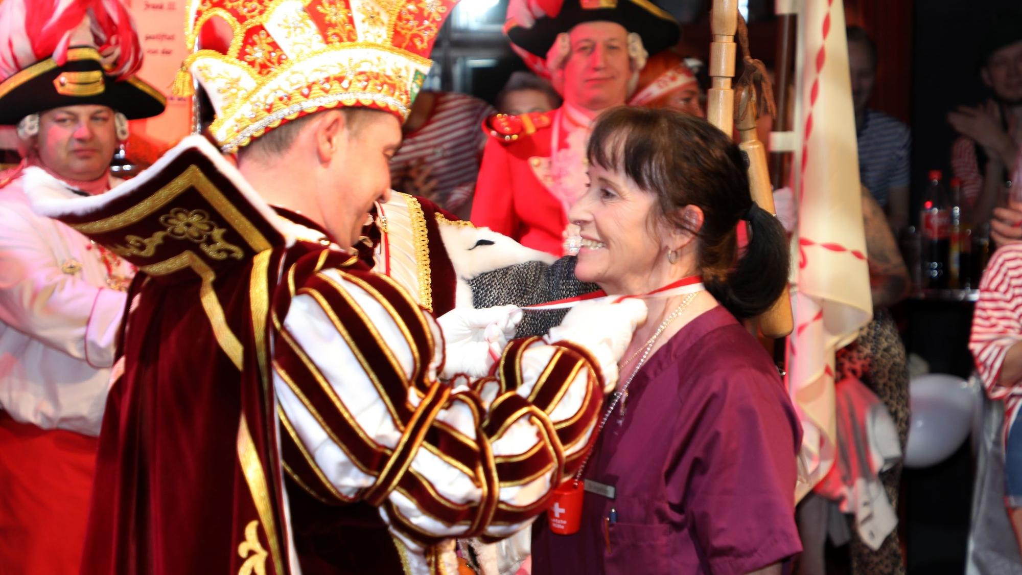 Prinz Frank I. (Haag), Gladbachs Vize-Feuerwehrchef, überreicht Ingeborg Schmidt einen Dreigestirnsorden.