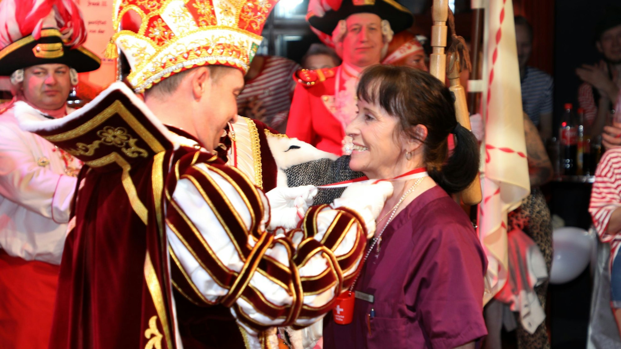 Prinz Frank I. (Haag), Gladbachs Vize-Feuerwehrchef, überreicht Ingeborg Schmidt einen Dreigestirnsorden.