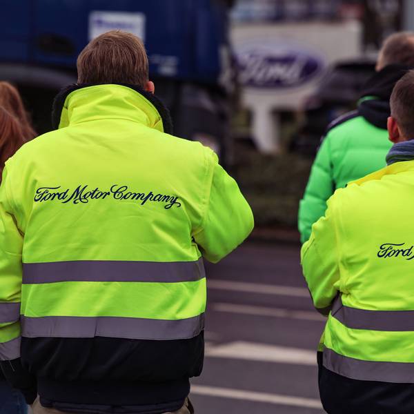 Mitarbeiter von Ford stehen vor dem Werksgelände.