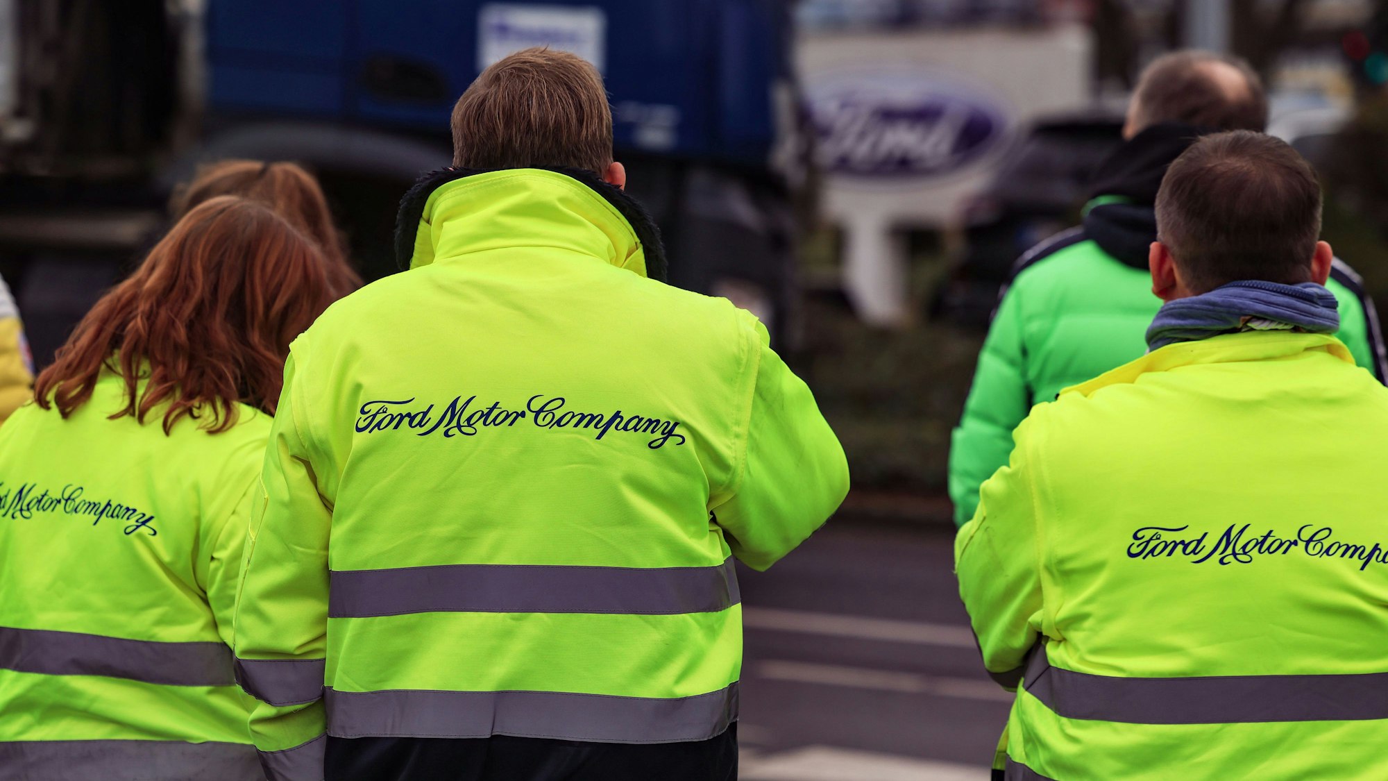 Mitarbeiter von Ford stehen vor dem Werksgelände.