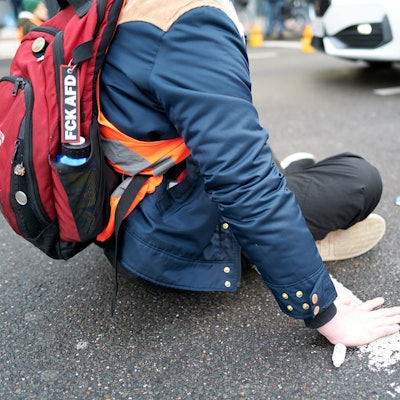 Aktivitsten der „Letzten Generation“ kleben sich auf der Fahrbahn fest.