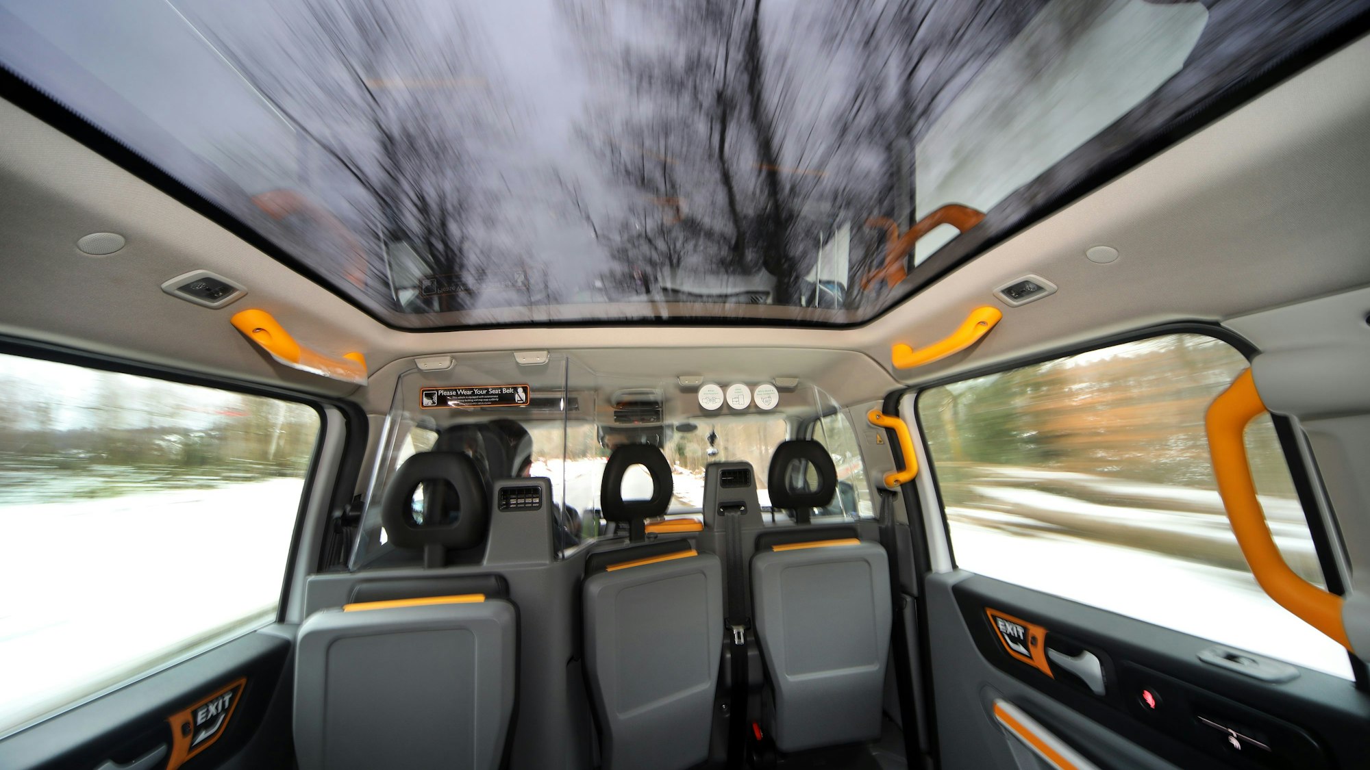 Das Innere eine Großraumtaxis zeigt Blicke hinaus in die Winterlandschaft und einen Ausblick durchs gläserne Dach.