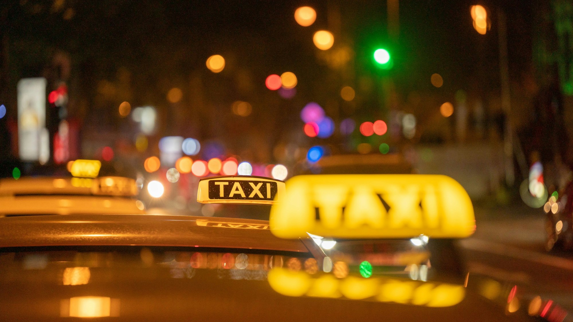 Mehrere Taxis stehen auf einer Straße.