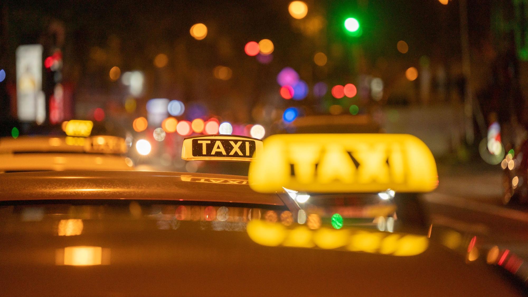 Mehrere Taxis stehen im Dunkeln an den Kölner Ringen und warten auf Kundschaft.